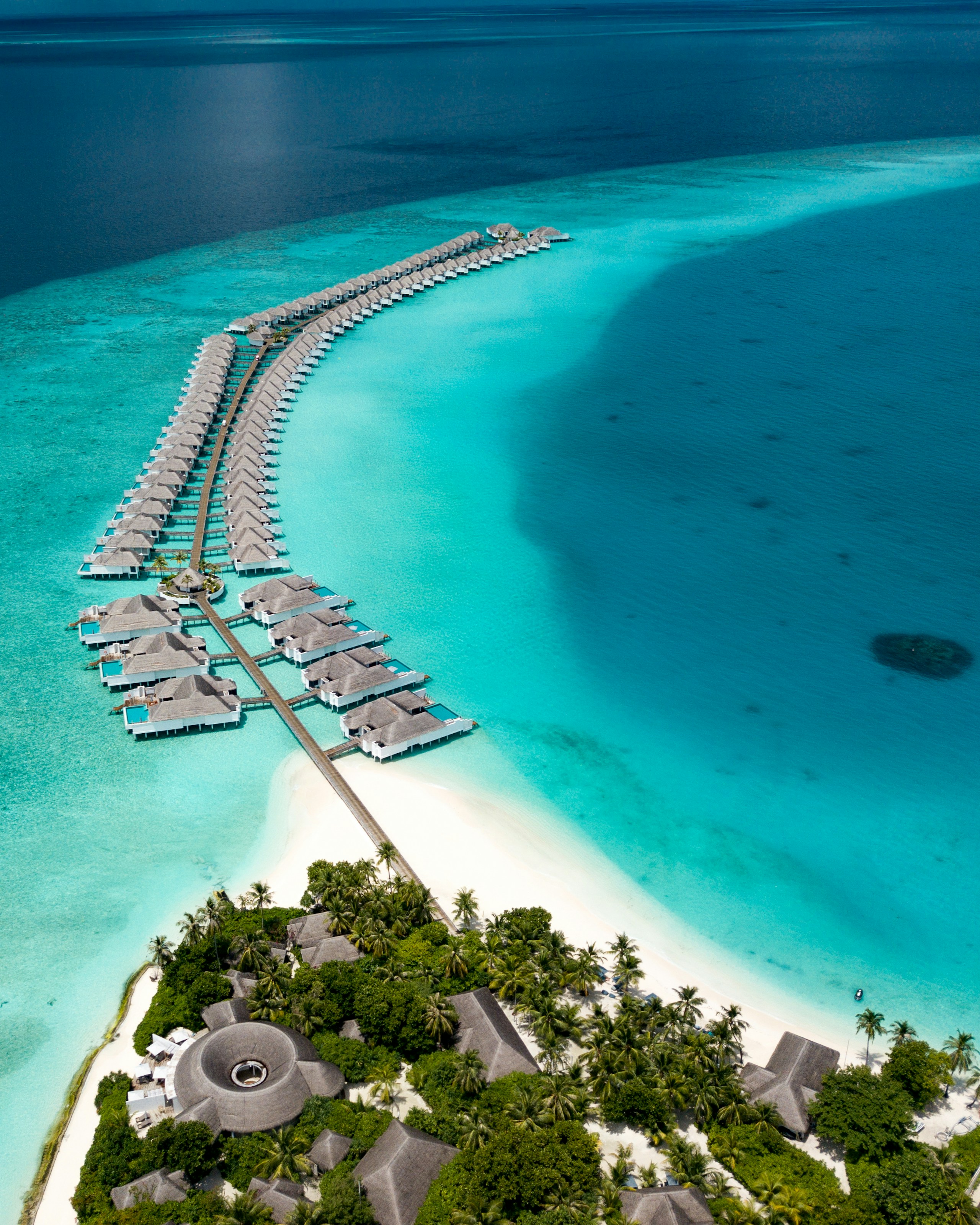 A sweep of private overwater villas above a turquoise lagoon in the Maldives